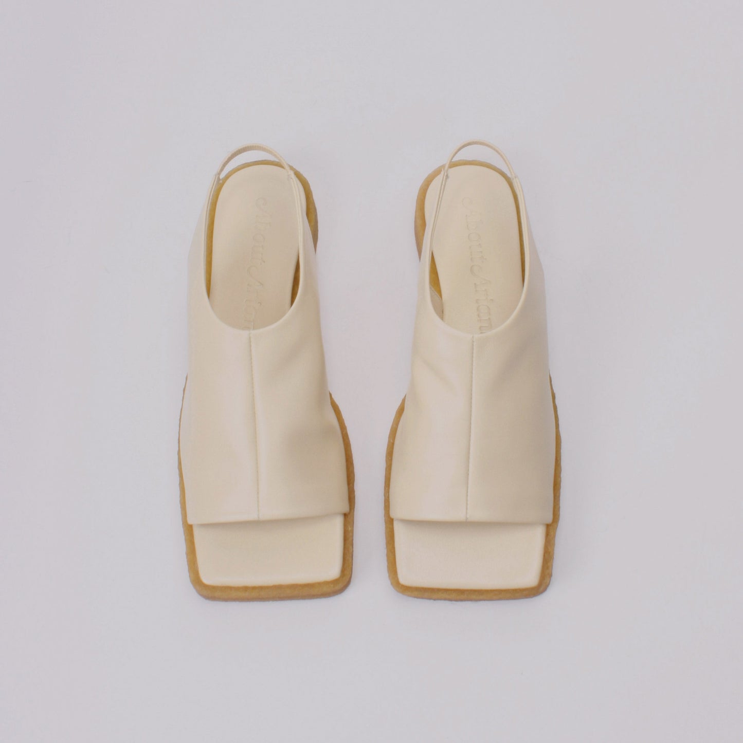 Unlined block platform sling-back sandals made of cream coloured lamb leather with a subtle shiny finish