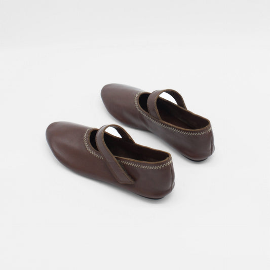 About Arianne Unlined flat mary-jane made of dark brown lamb nappa leather with a shiny finish and stitching details.