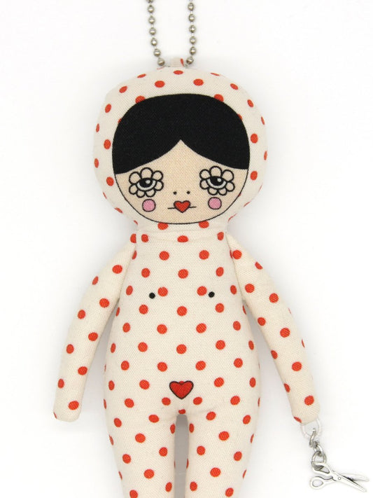 Polka dot doll keychain with floral design eyes on a white background