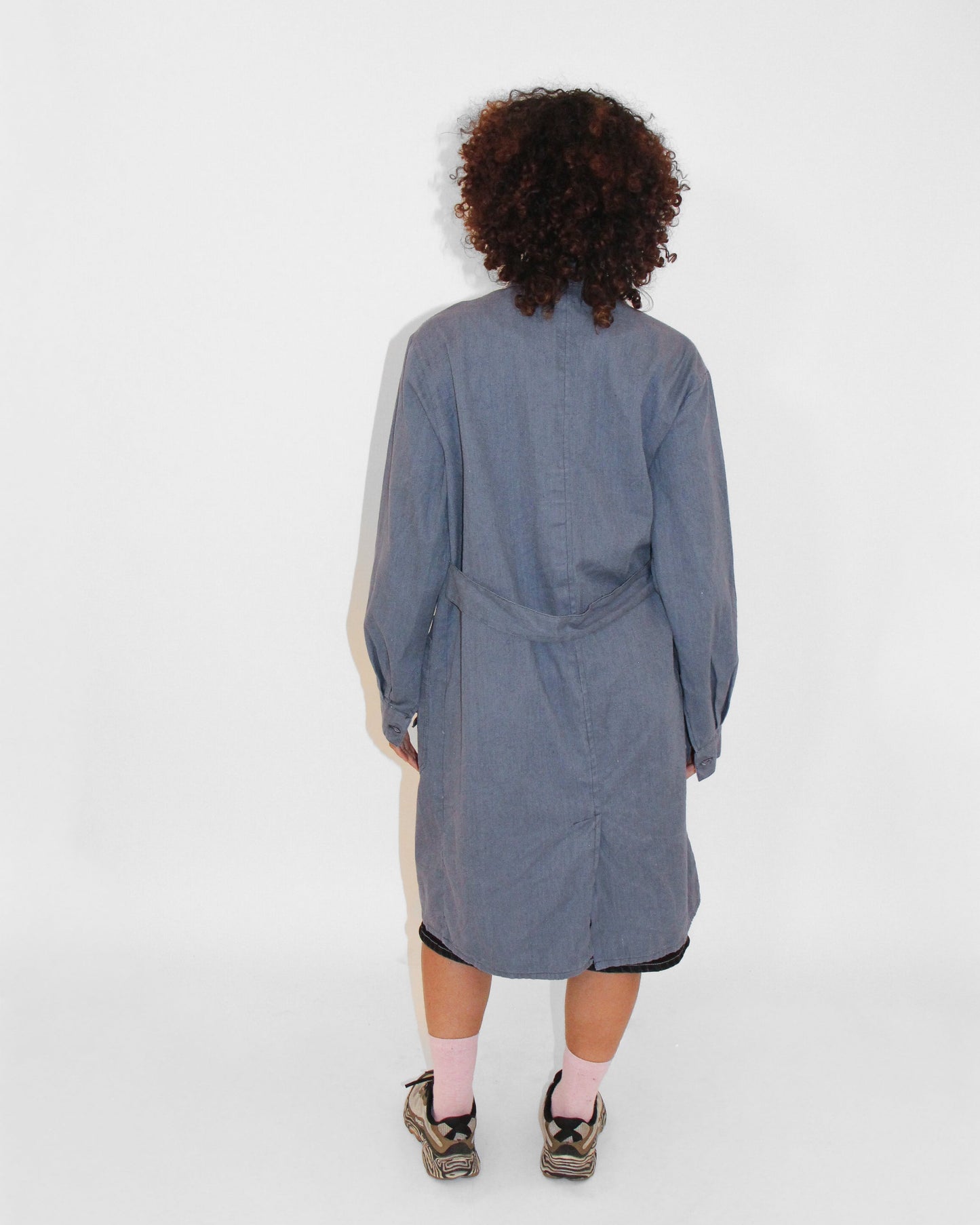 Person wearing a gray coat with a white background