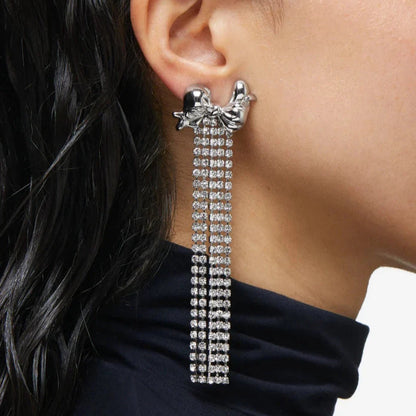 Silver-plated bow earrings with crystal chain fringe.