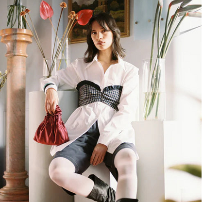 Woman sitting in a stylish room with plants and decor