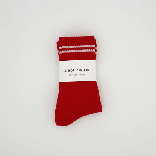 Red socks with white stripes on a white background, featuring 'Le Bon Shoppe' branding.