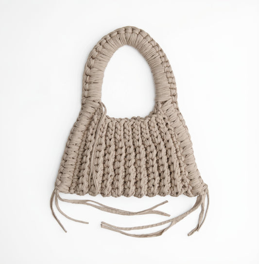 Beige woven handbag with tassels on a white background