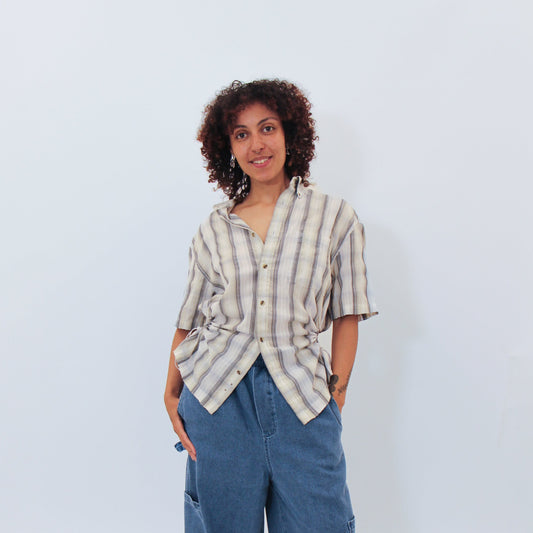 Person wearing a striped shirt and blue jeans against a white background