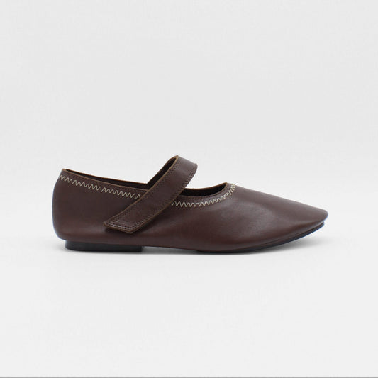 Unlined flat mary-jane made of dark brown lamb nappa leather with a shiny finish and stitching details. 