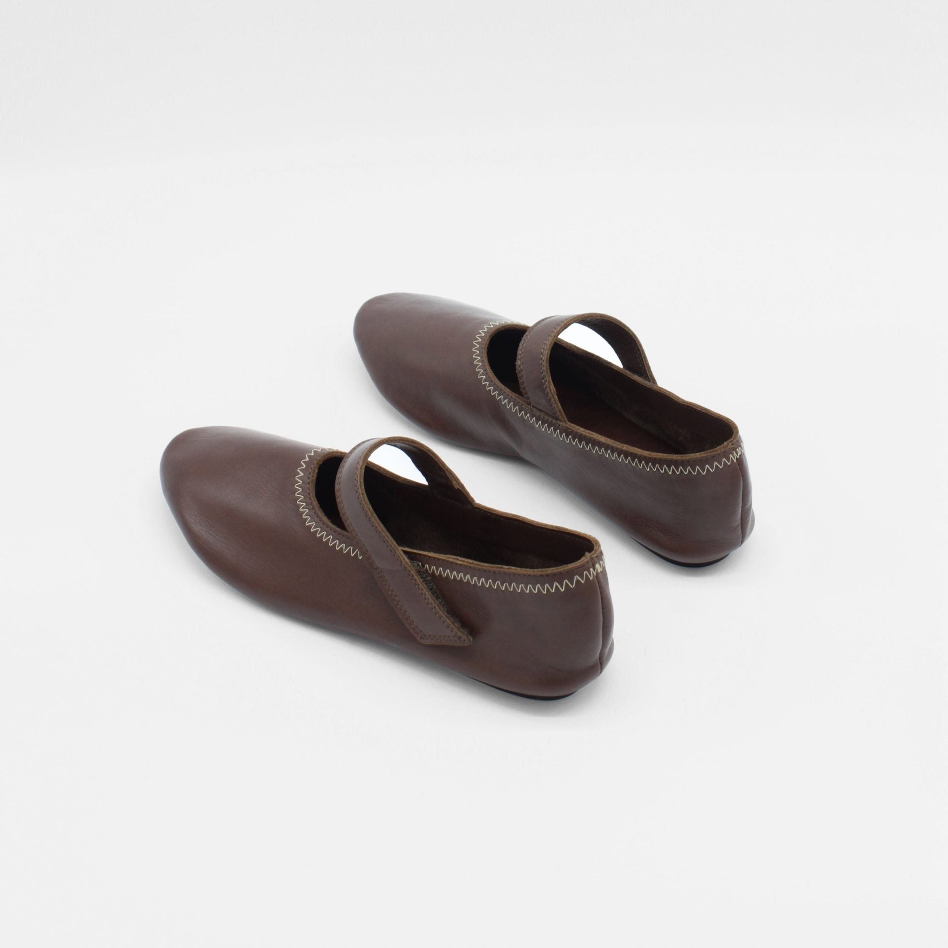 About Arianne Unlined flat mary-jane made of dark brown lamb nappa leather with a shiny finish and stitching details. 