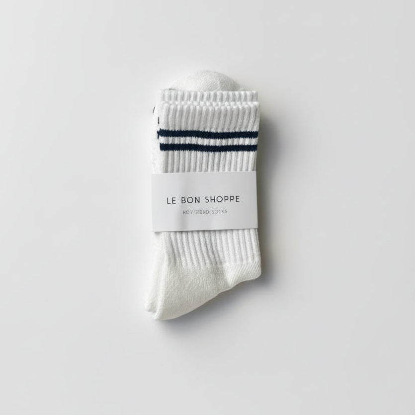 White socks with black stripes and a visible brand label on a light gray background