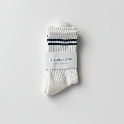 White socks with black stripes and a visible brand label on a light gray background
