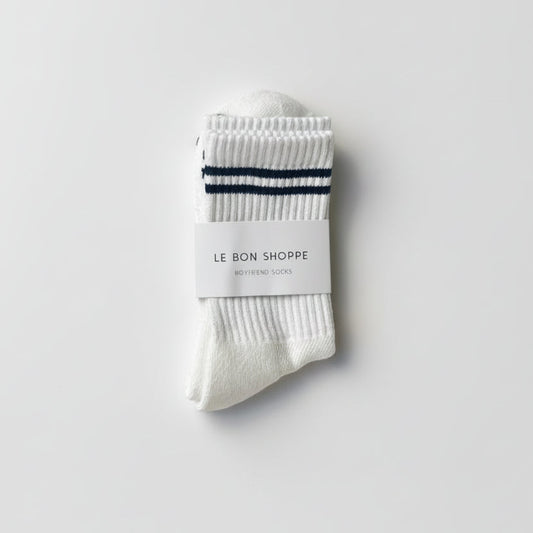 White socks with black stripes and a visible brand label on a light gray background