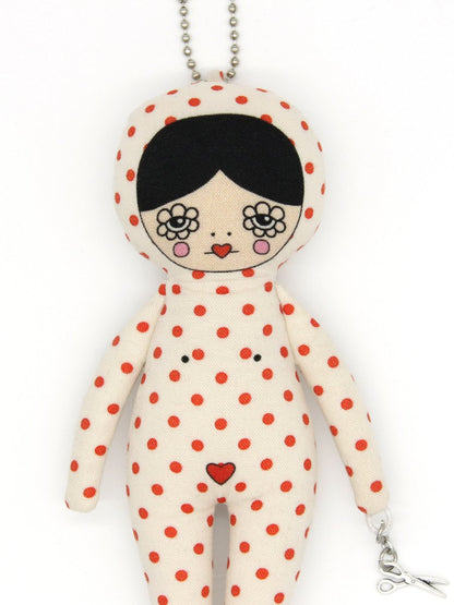 Polka dot doll keychain with floral design eyes on a white background