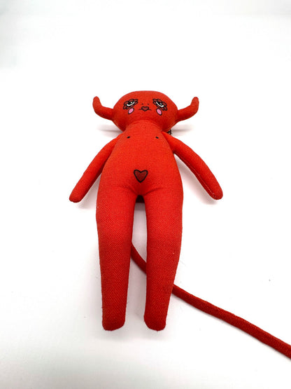 Red plush toy with a heart on a white background