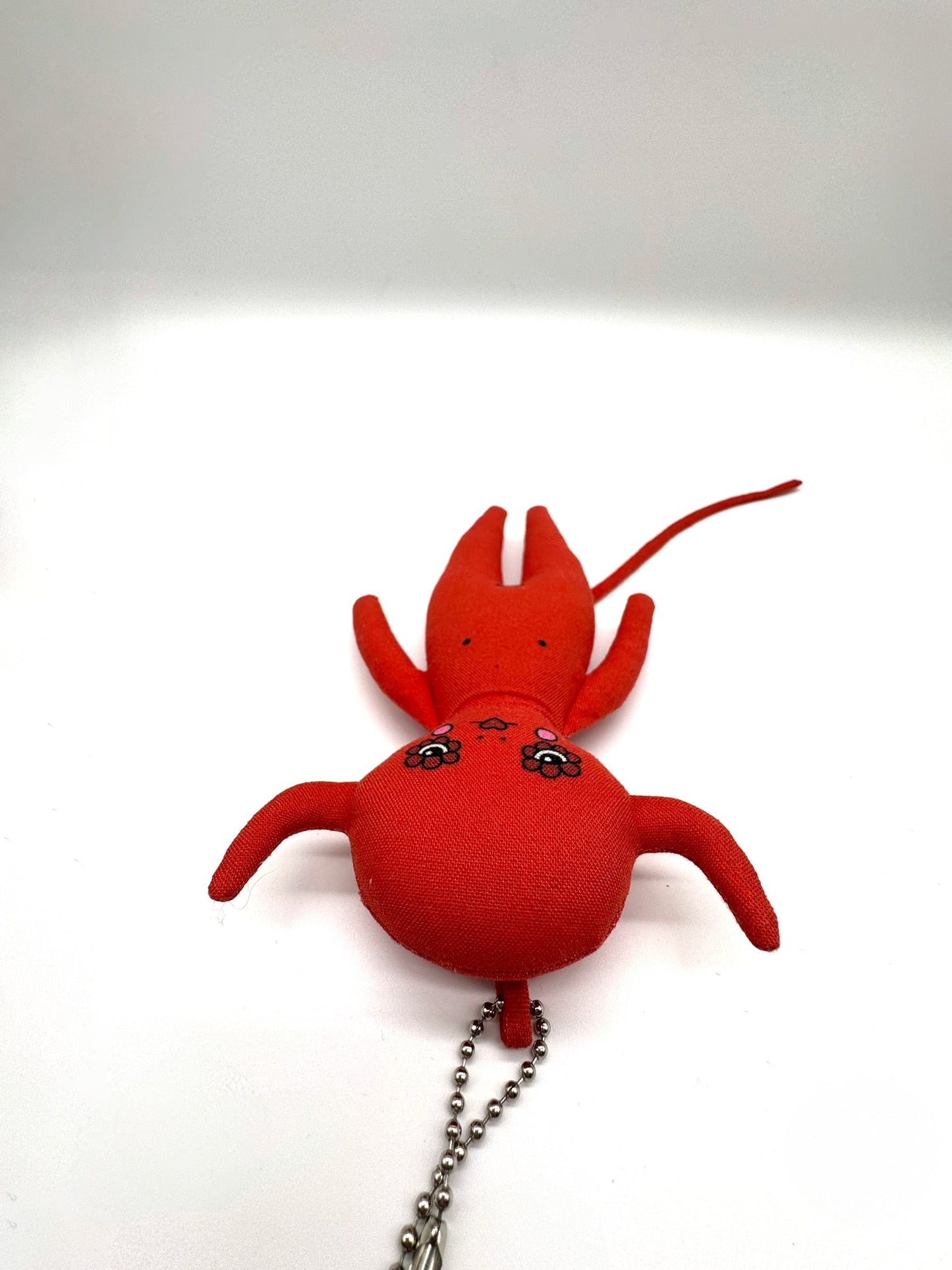 Red lobster-shaped keychain on a white background