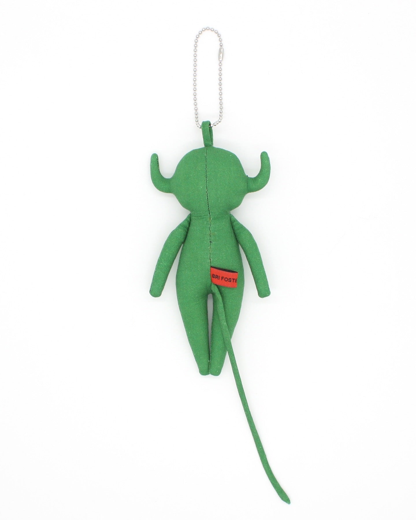 Green plush devil toy charm with a red label on a white background