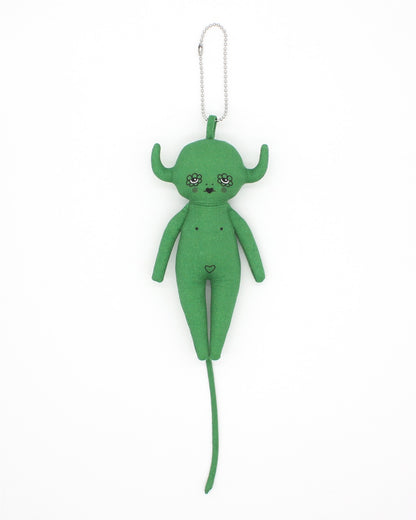 Green plush devil toy charm with long tail on a white background