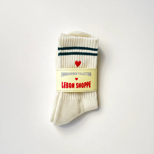 Pair of white socks with a red heart and text on a light gray background