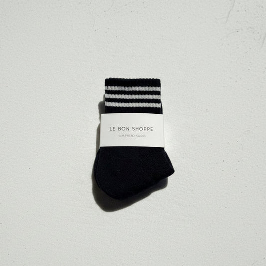 Black socks with white stripes on a light gray background, featuring 'Le Bon Shoppe' label.
