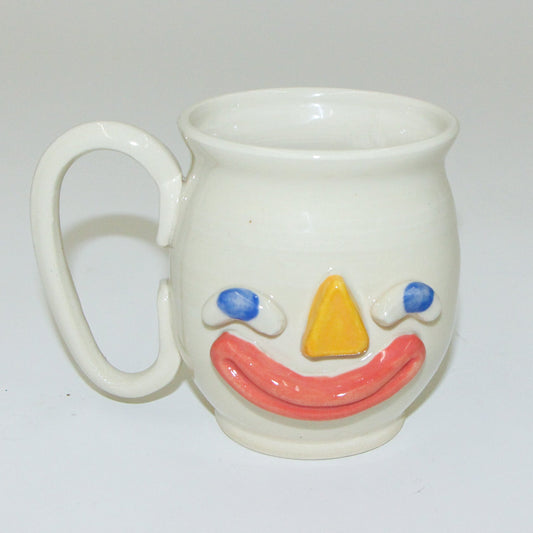 White mug with a colorful face design on a white background