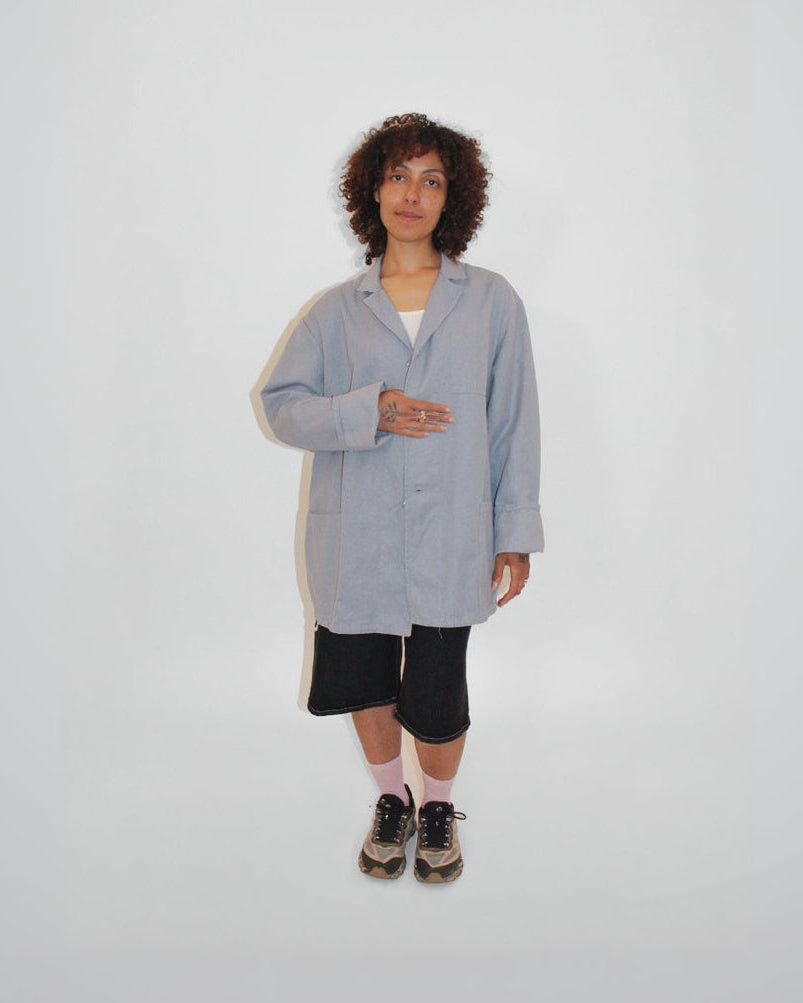 Person wearing a light gray coat on a white background