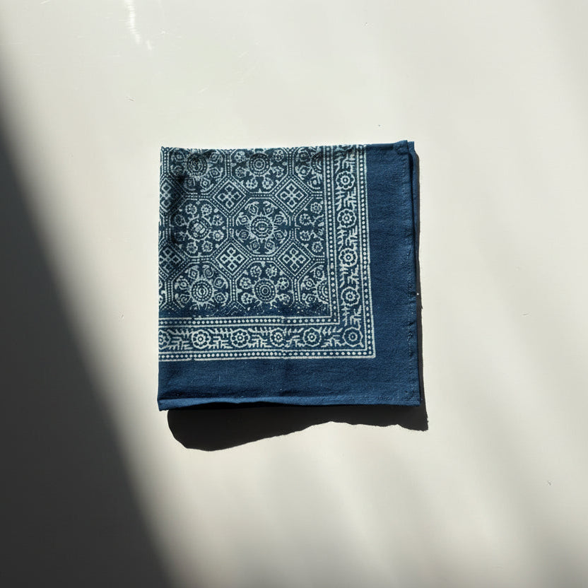 Blue bandana with white patterns on a reflective surface