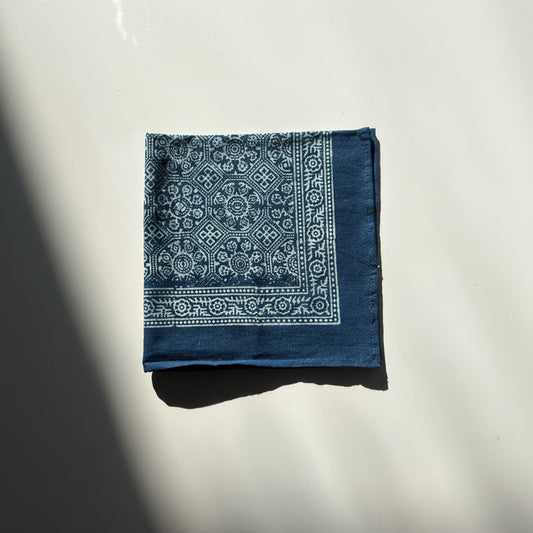 Blue bandana with white patterns on a reflective surface