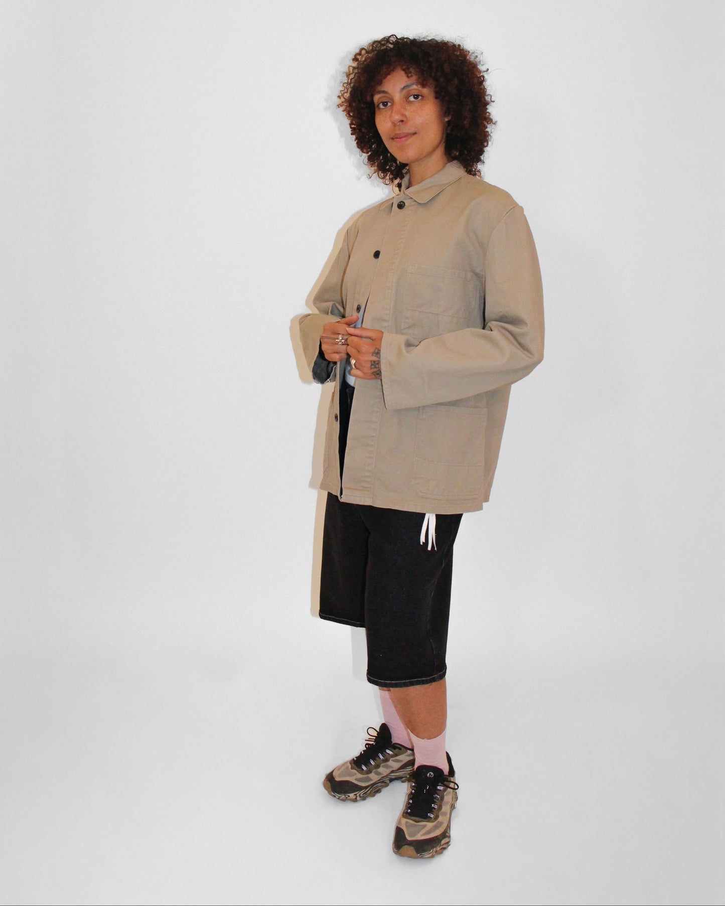 Person wearing a beige coat on a white background