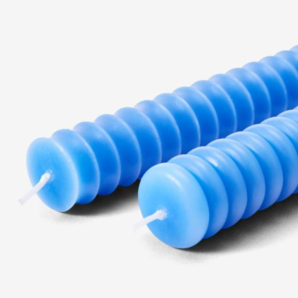 Two cobalt blue taper candles with ribbed texture